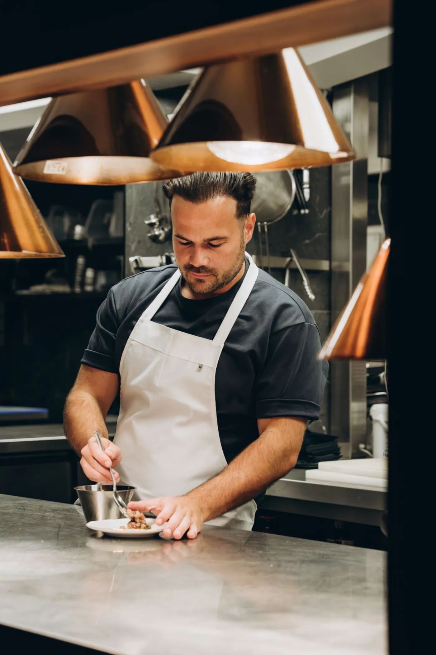 Chef Julius Nuiten dresseert een gerecht in de keuken van Le Souterrain