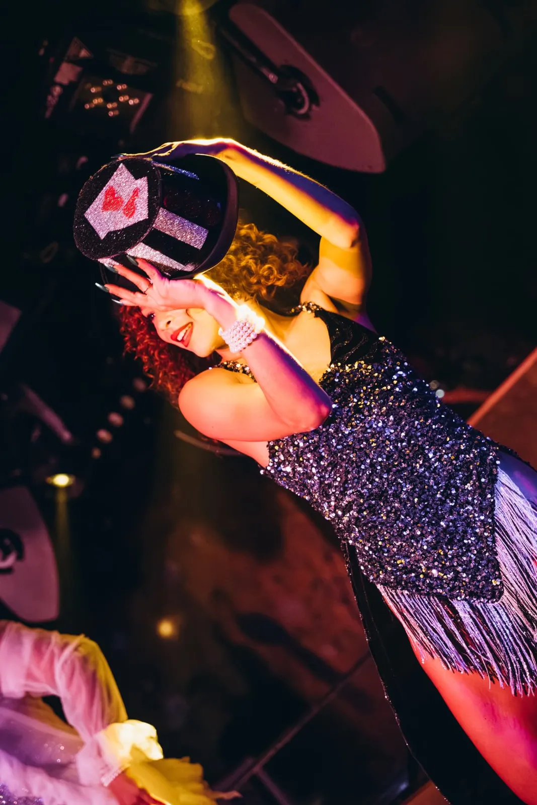 Performer with a sparkling top hat at the Dinner Show, Le Souterrain